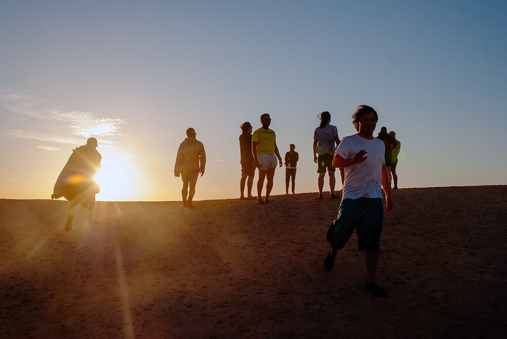 A group of people walking during sunset