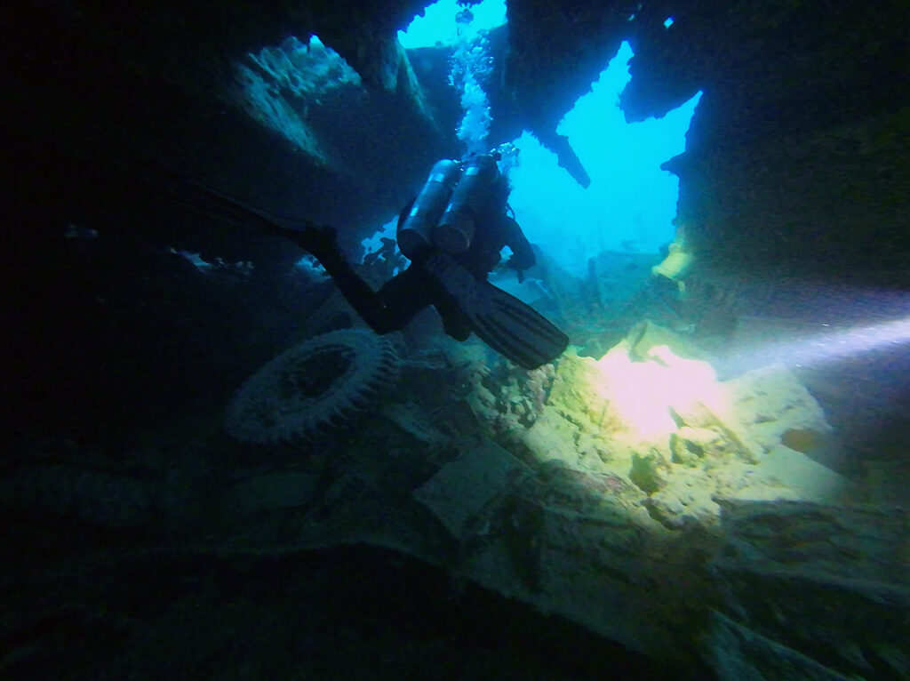 Divers swimming through a big wreck, SS Thistlegorm